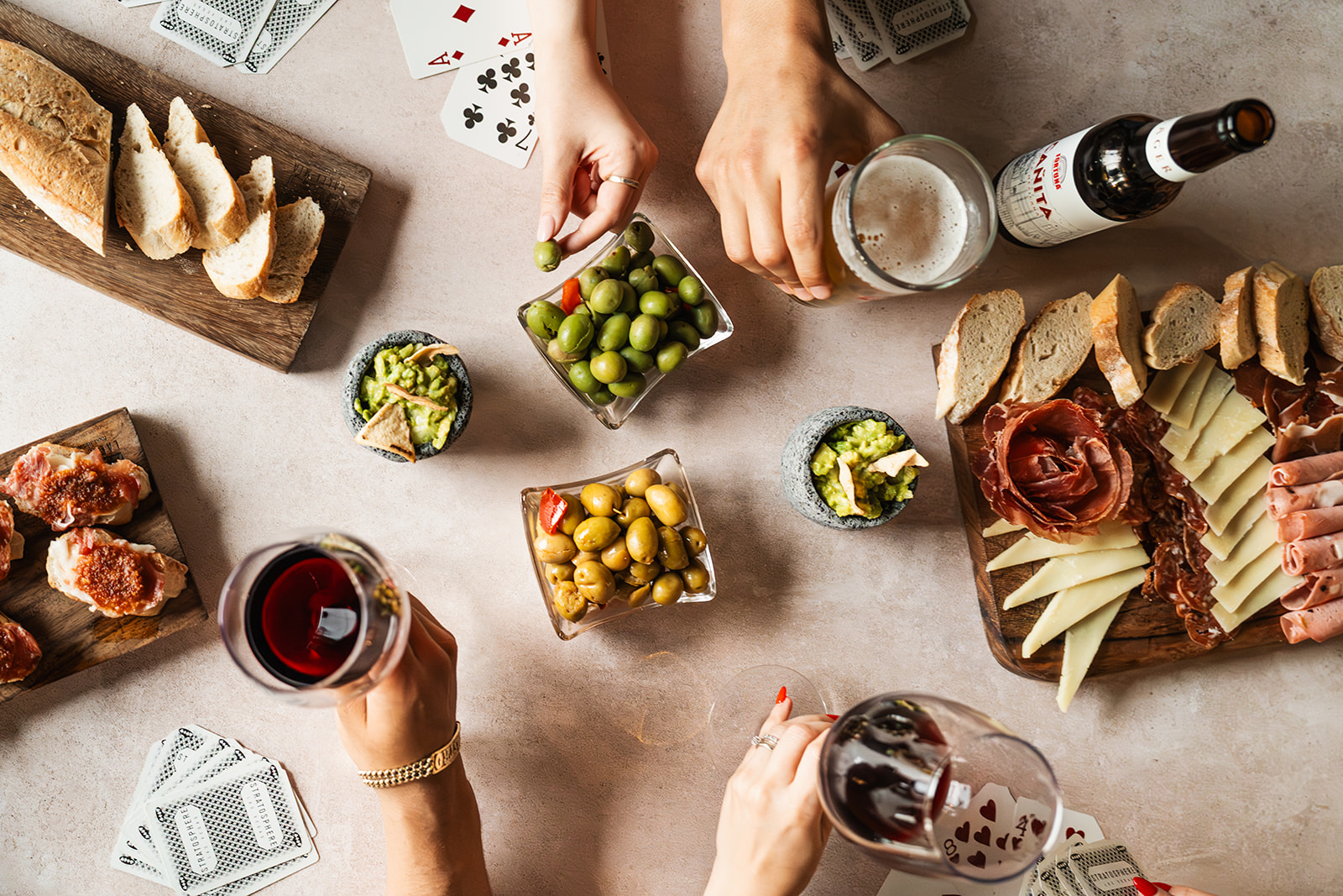 Mesa con tabla de charcutería, aceitunas, pan y bebidas
